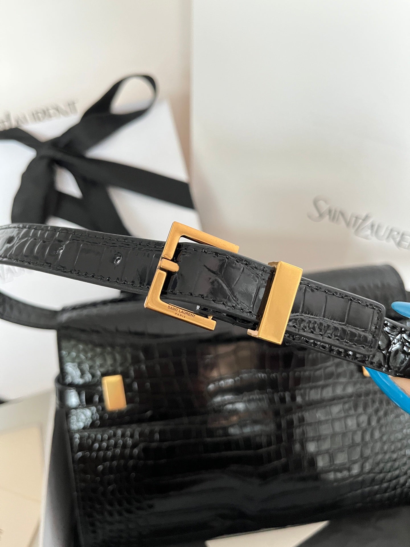 Black crocodile-embossed handbag with gold buckle on front strap