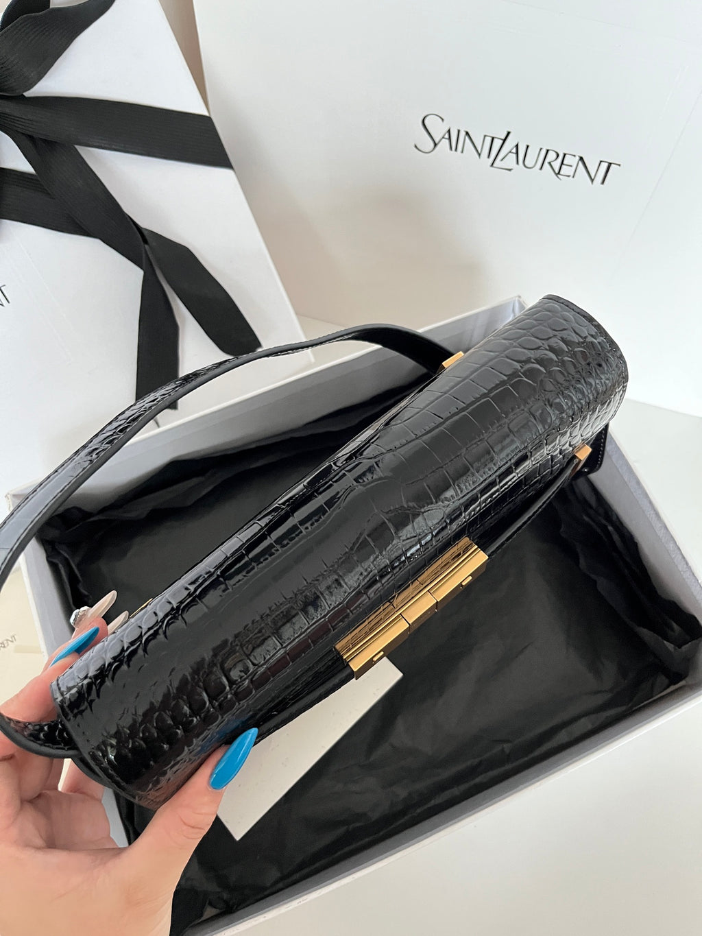 Open black crocodile-embossed handbag with gold bar hardware and top handle