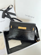 Crocodile-embossed handbag with black strap and gold clasp, shown in front view