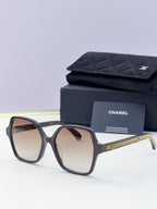 Eyeglasses with dark frame, warm brown lenses, gold chain temple, with case