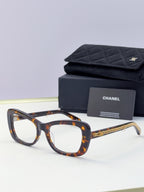 Tortoiseshell square sunglasses with orange-tinted lenses and gold chain temple detail