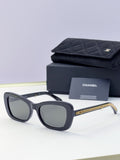 Black rectangular sunglasses with dark lenses and gold chain temples