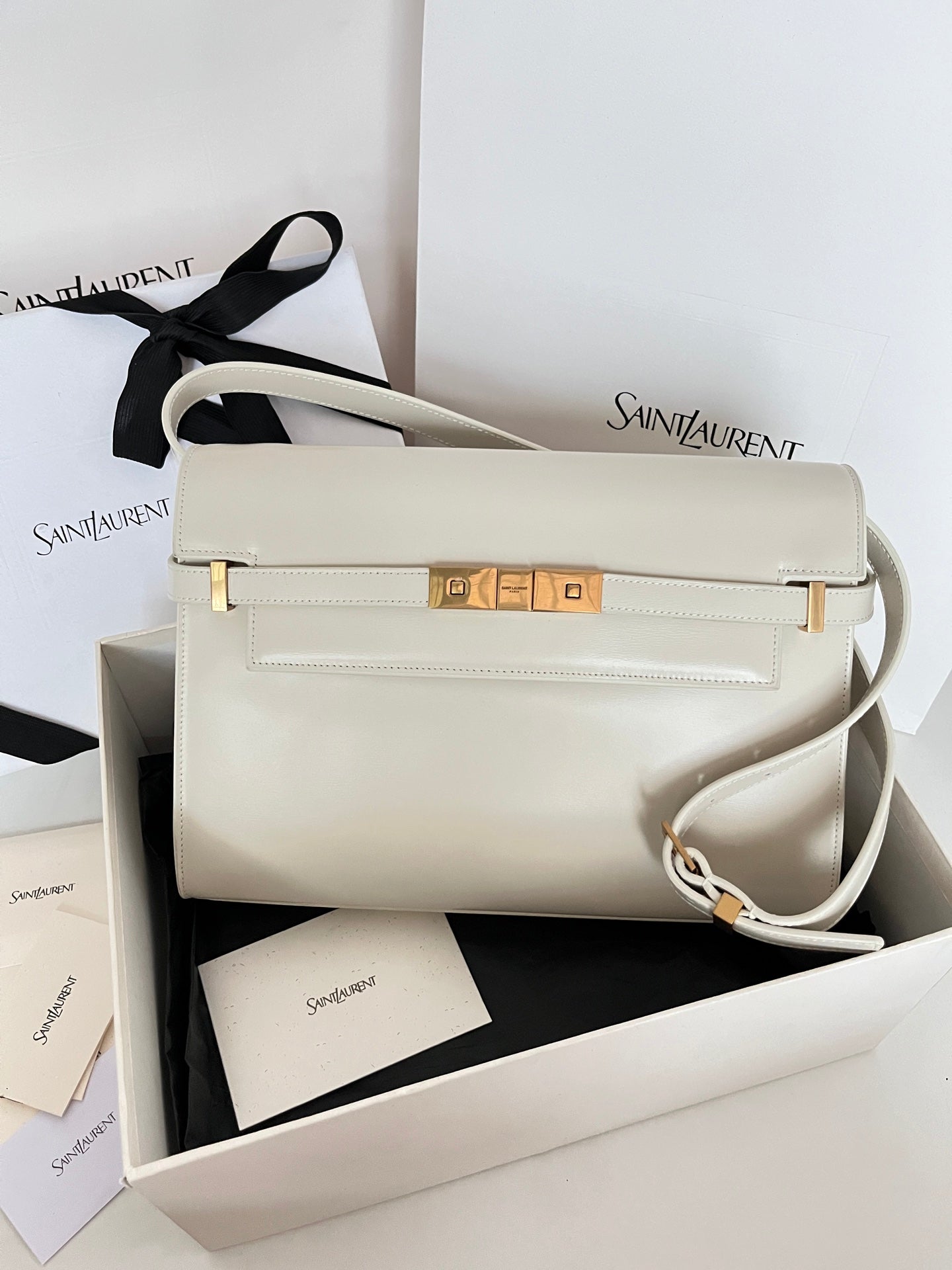 Ivory leather shoulder bag with gold clasp and crossbody strap, front flap detail
