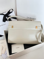 Ivory leather shoulder bag with front flap, gold hardware accents, side view