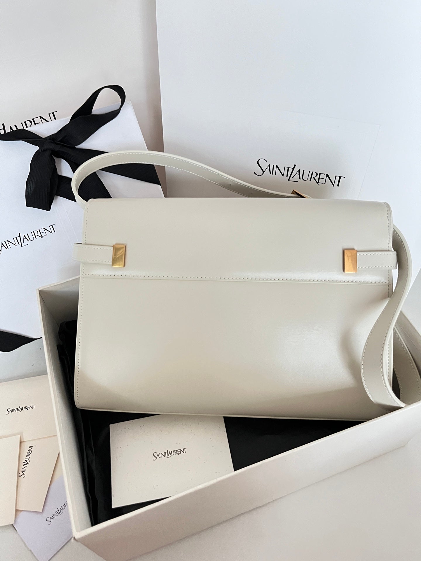 Ivory leather shoulder bag with front flap, gold hardware accents, side view