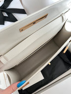 Ivory leather bag interior with side compartment and gold-toned closure bar
