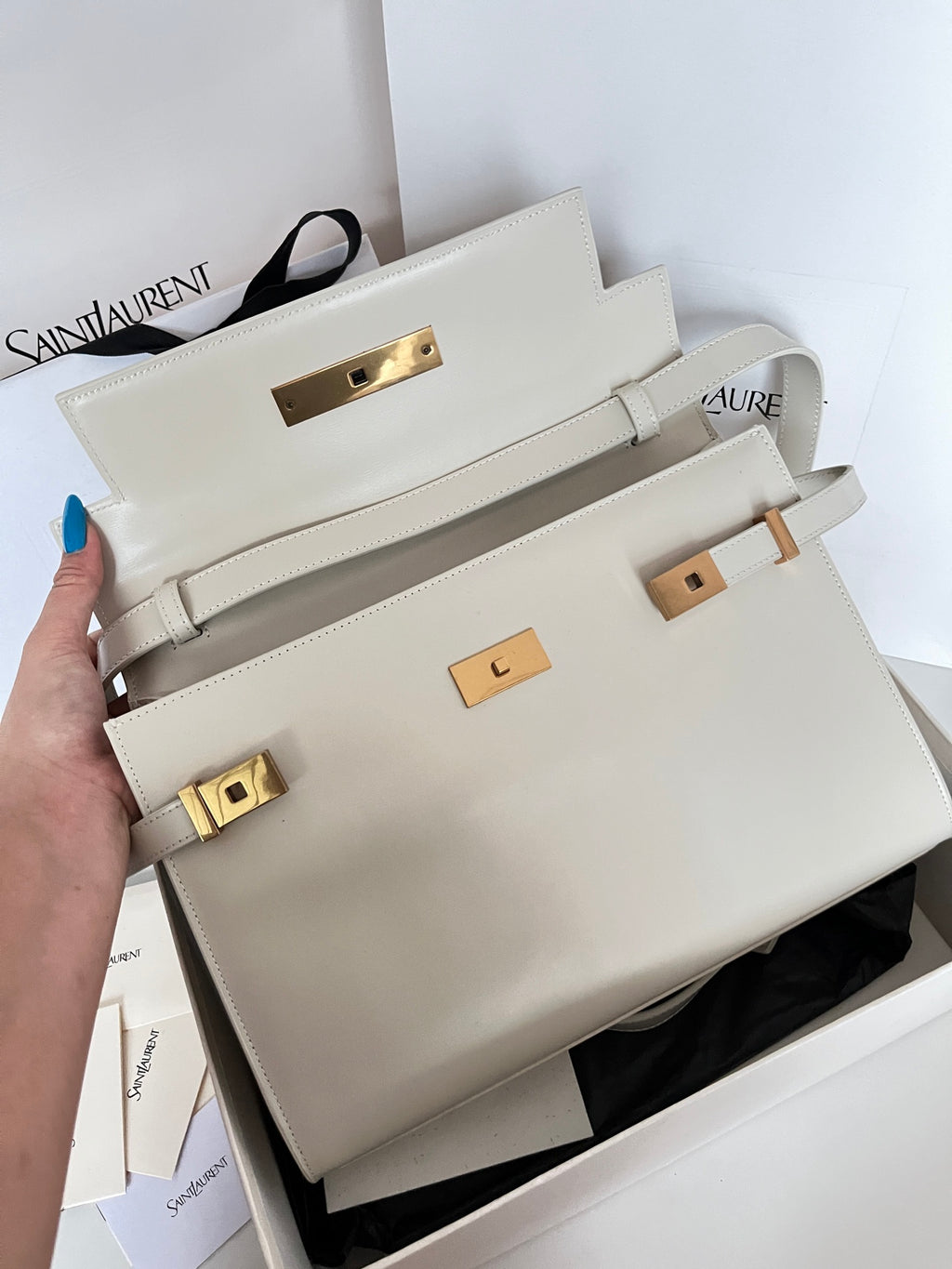 Ivory leather satchel with front flap and gold-toned clasp, top handle