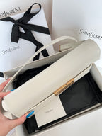 Ivory leather shoulder bag open top view, gold bar closure, crossbody strap