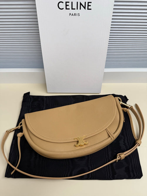 Celine crossbody bag in tan with curved flap and gold-tone clasp, adjustable strap