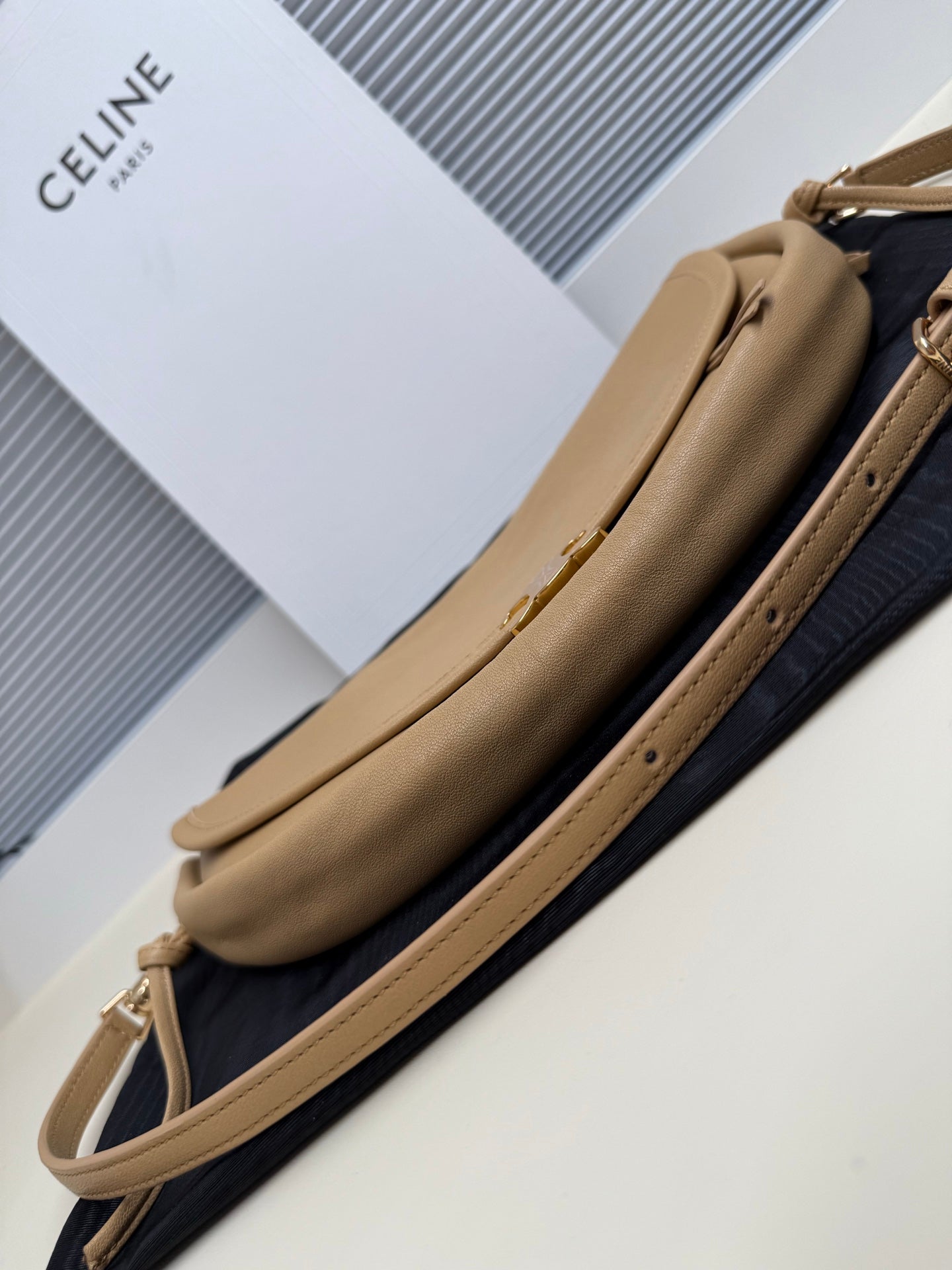 Celine crossbody bag side view in tan with long strap and gold-tone hardware