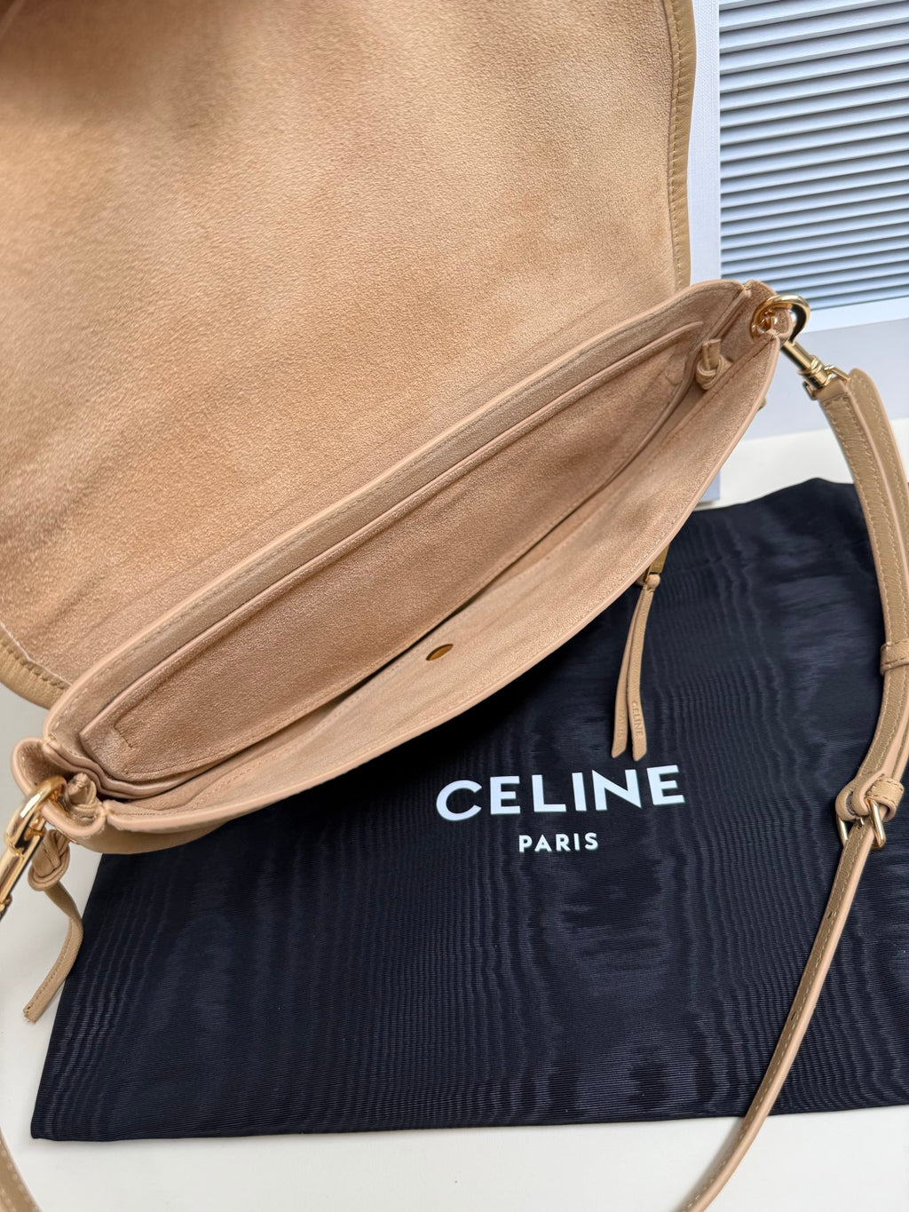 Celine crossbody bag in tan with top zip and tassel pull, adjustable strap