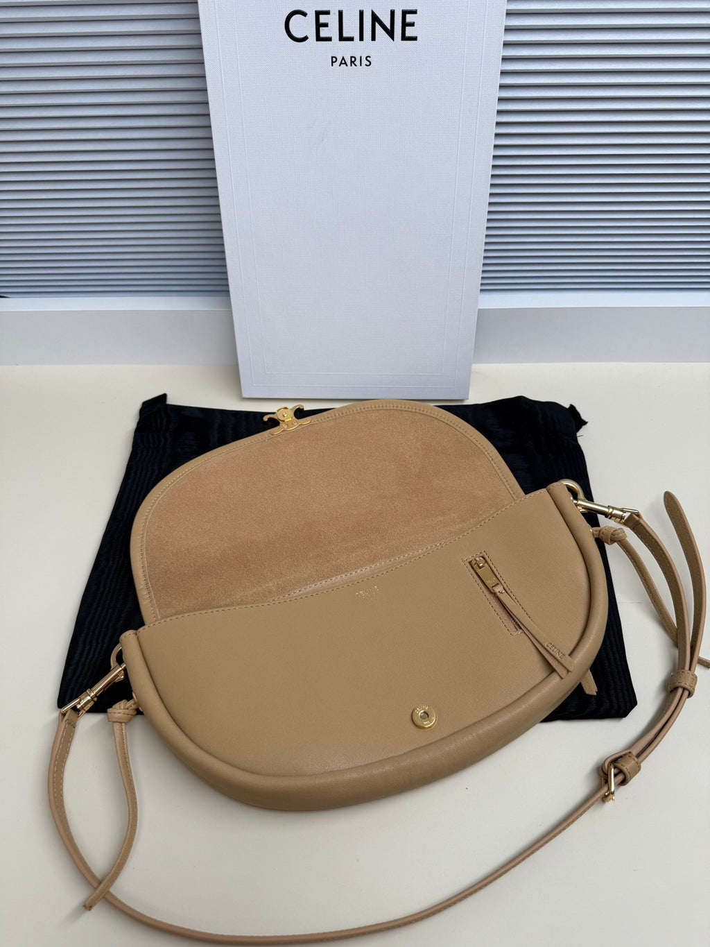 Celine crossbody bag in tan with rounded silhouette, zipper pull, adjustable strap
