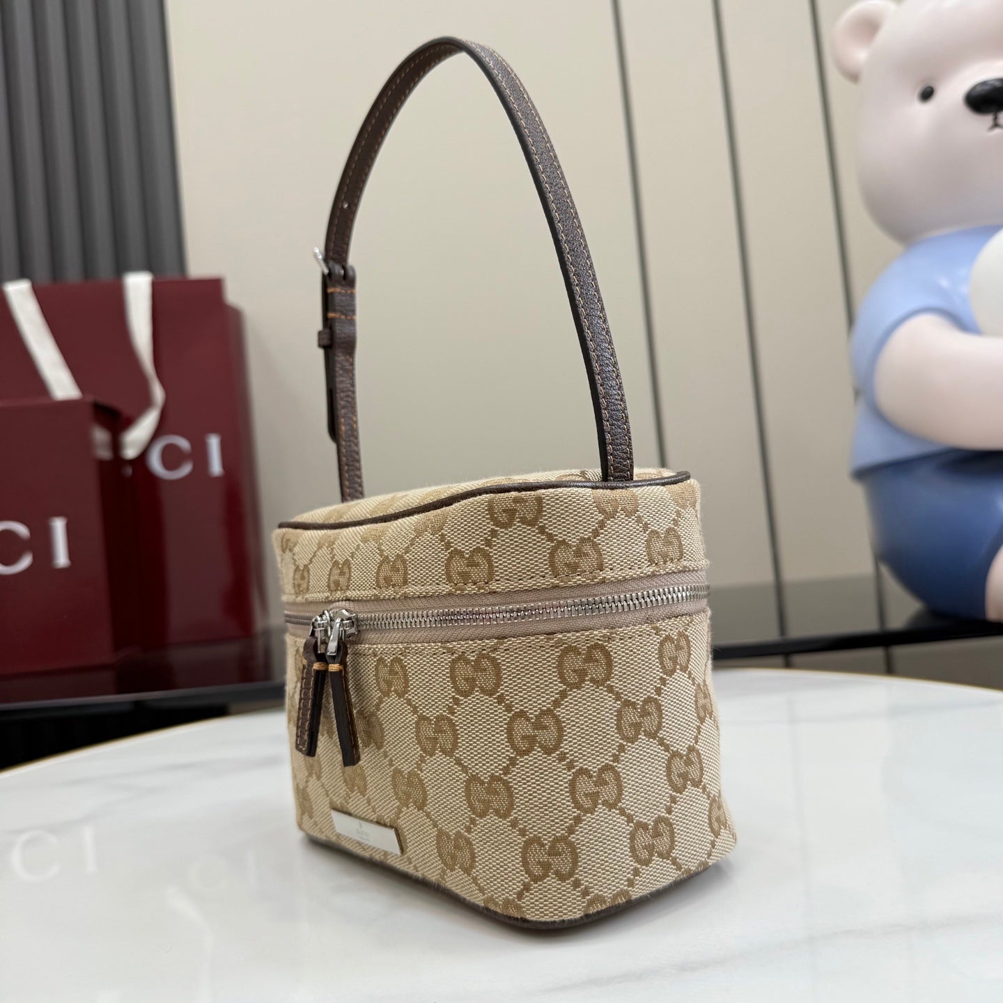 Handbag with beige GG canvas, dark leather handle, top zip and front panel detail