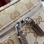 Handbag zipper close-up on beige GG canvas with silver zipper and dark leather tab