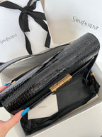 YSL black croc-texture handbag side view with gold-tone trim and strap