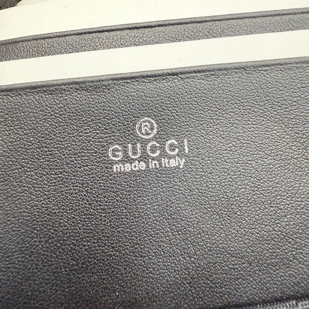 Black pebbled leather bag exterior with Gucci logo stamp and “made in Italy”