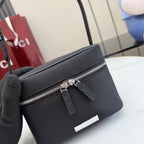 Black pebbled leather mini bag showing zipper track, pull tab, and inner tag