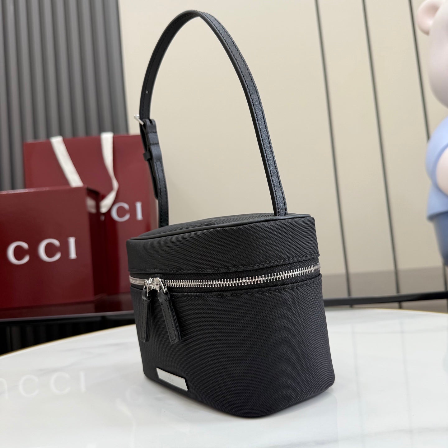 Black pebbled leather mini shoulder bag with top zip and adjustable strap