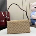 Gucci bag with GG canvas front, dark leather trim, and curved top handle