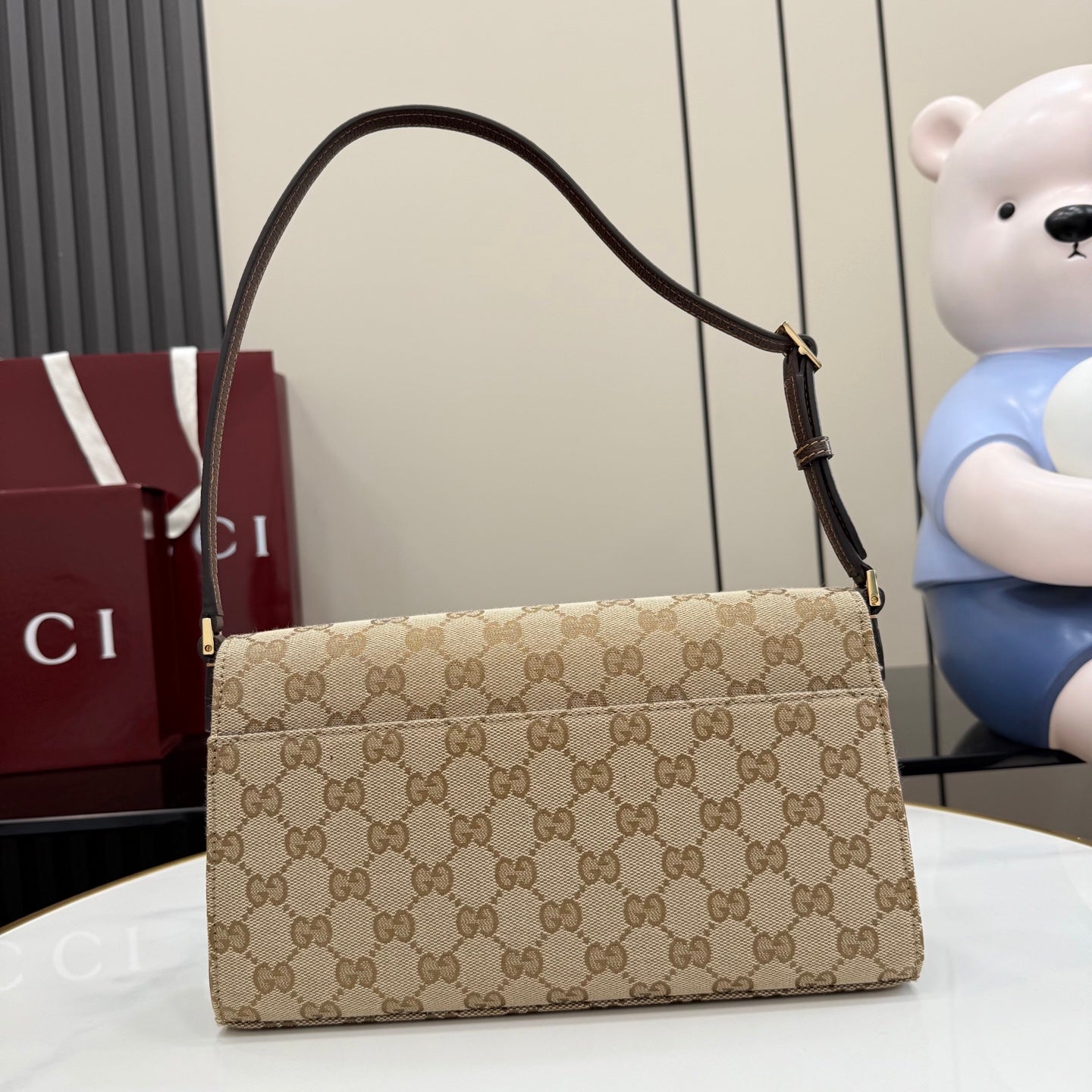 Gucci bag with GG canvas front, dark leather trim, and curved top handle