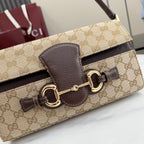 Gucci bag close-up of front closure, GG canvas with dark leather panel and gold hardware
