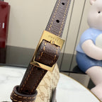 Gucci bag close-up of leather strap with gold buckle and logo hardware