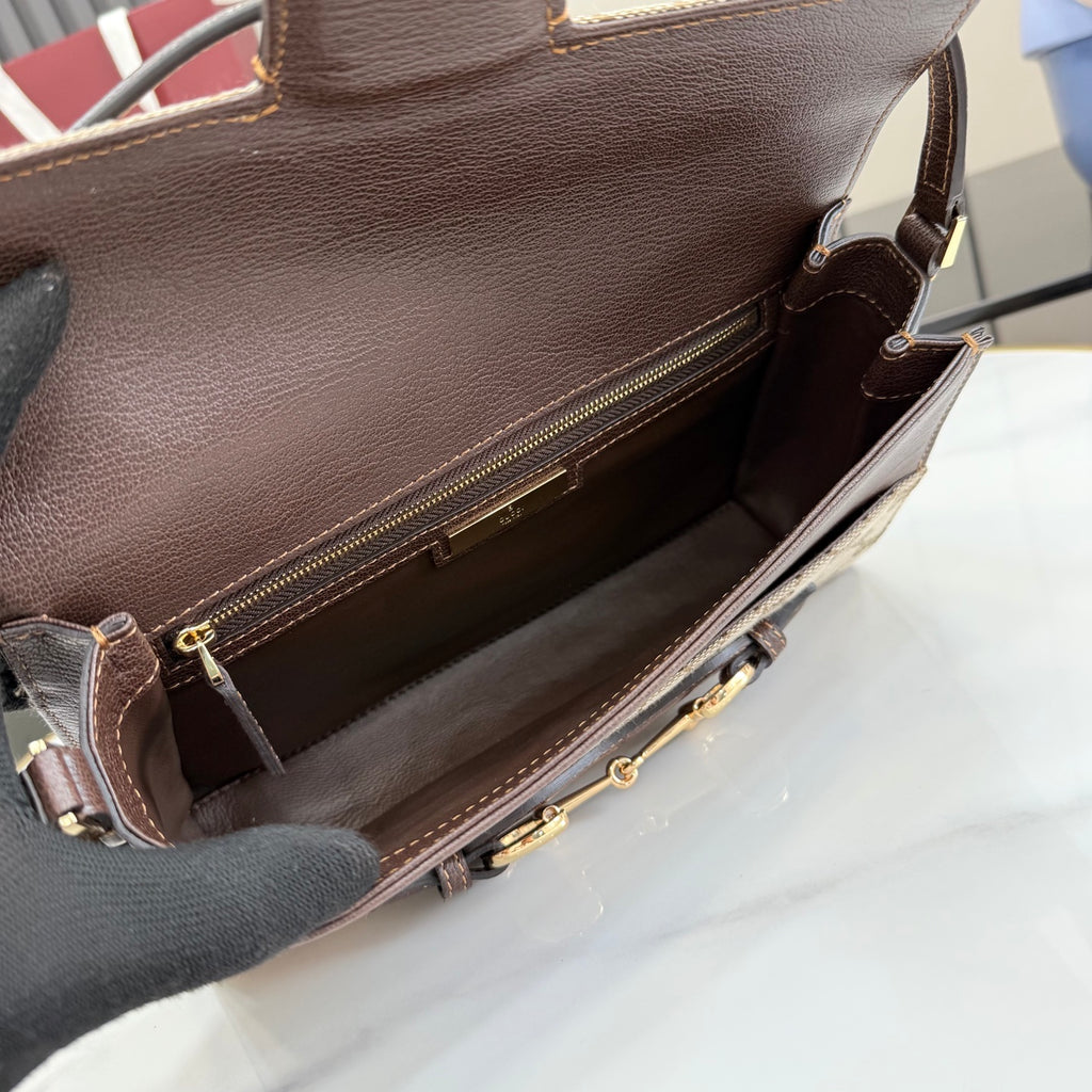 Gucci bag interior view with zip opening, dark leather lining and gold-tone hardware