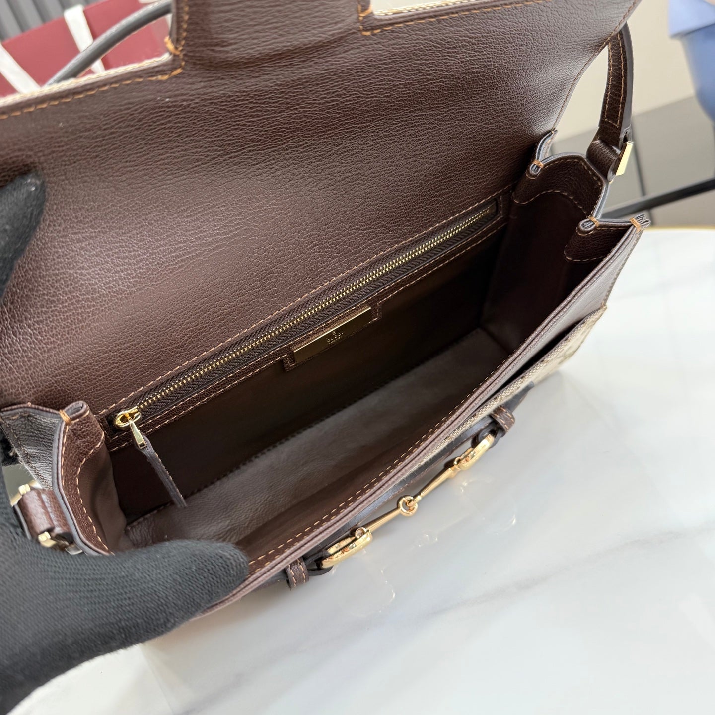 Gucci bag interior view with zip opening, dark leather lining and gold-tone hardware