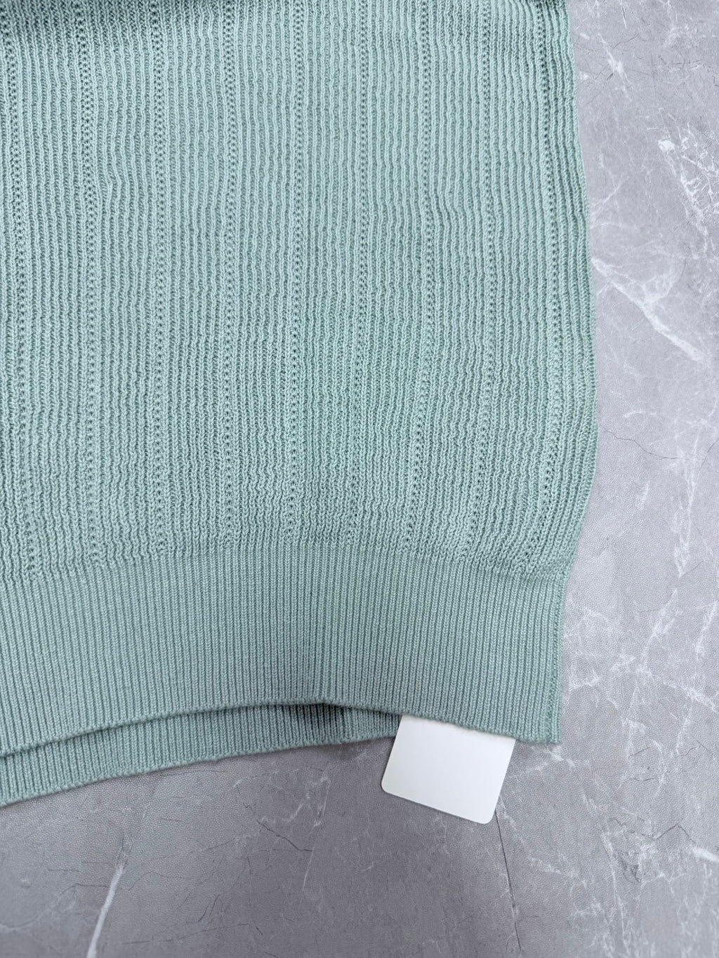Light blue knit polo shirt hem with ribbed trim