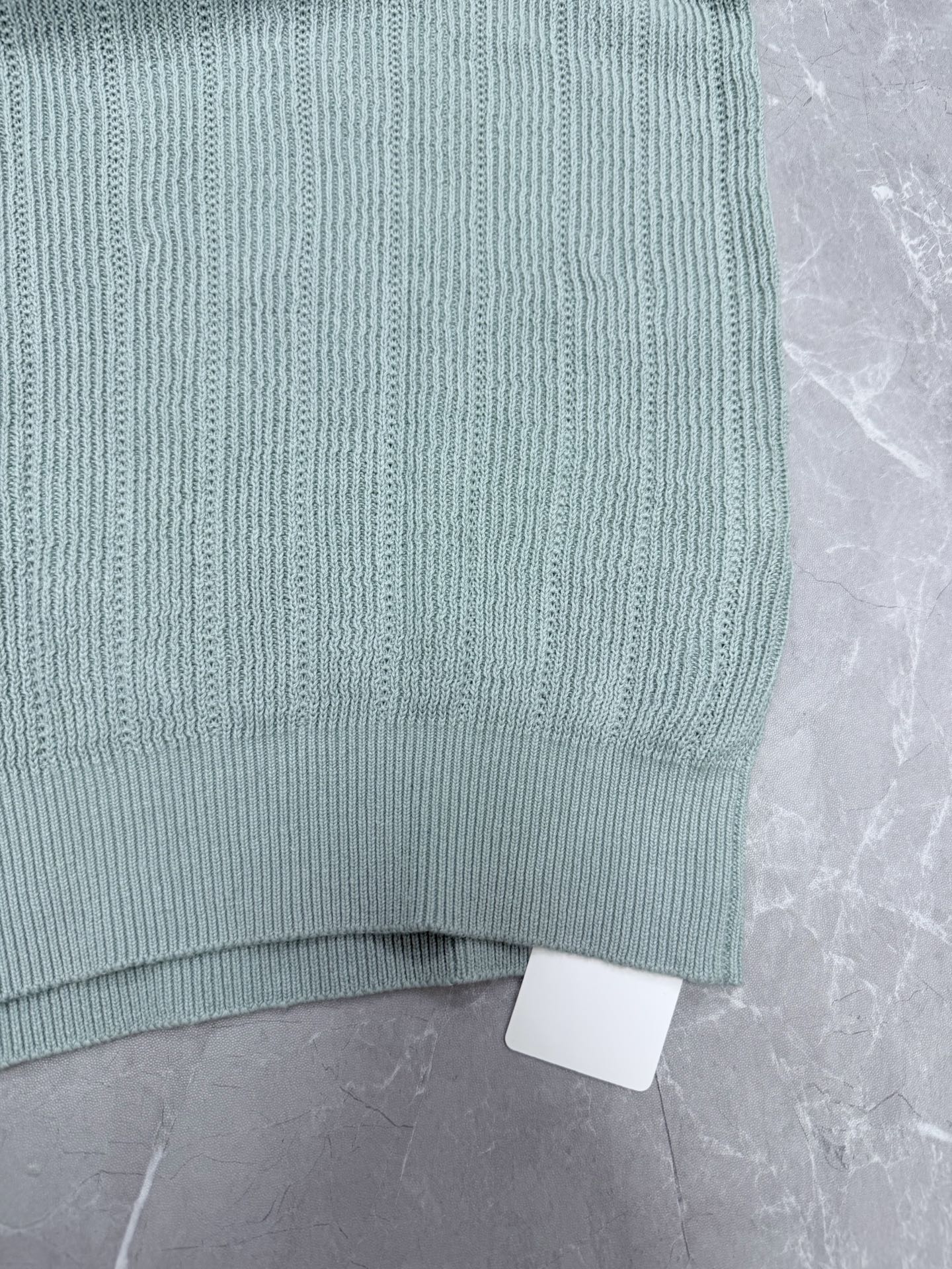 Light blue knit polo shirt hem with ribbed trim