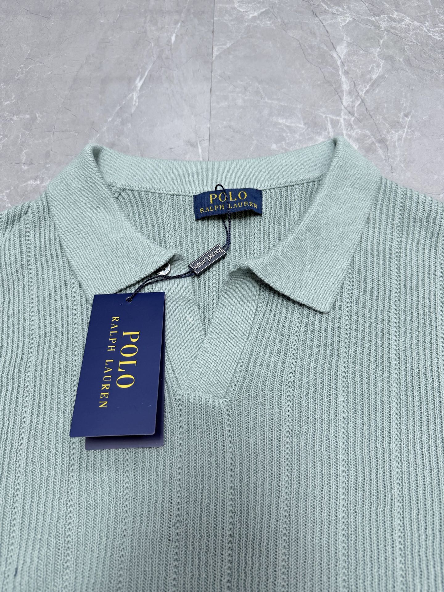 Light blue knit polo shirt collar with button placket and brand tag