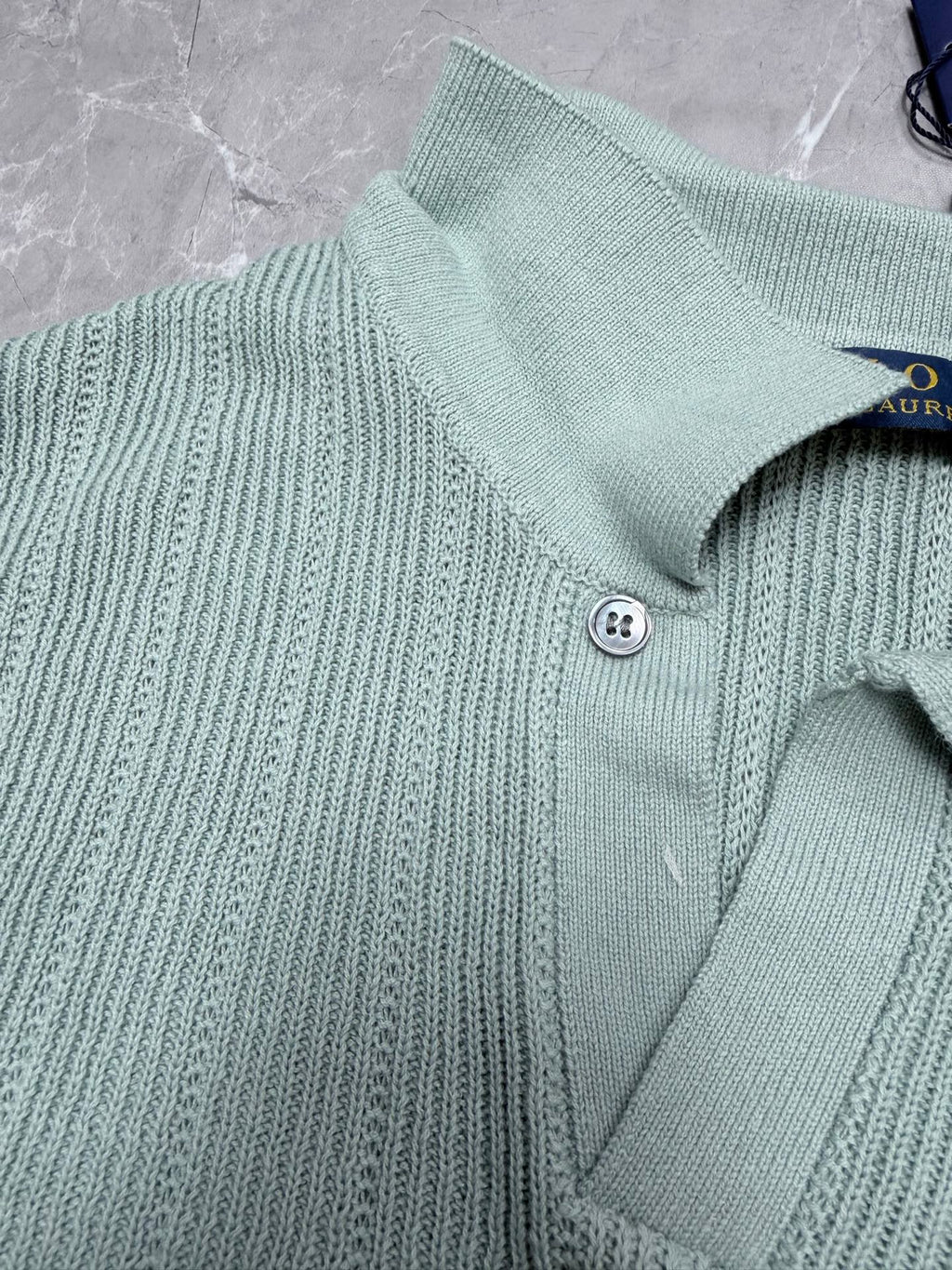 Light blue knit polo shirt neckline with two-button placket