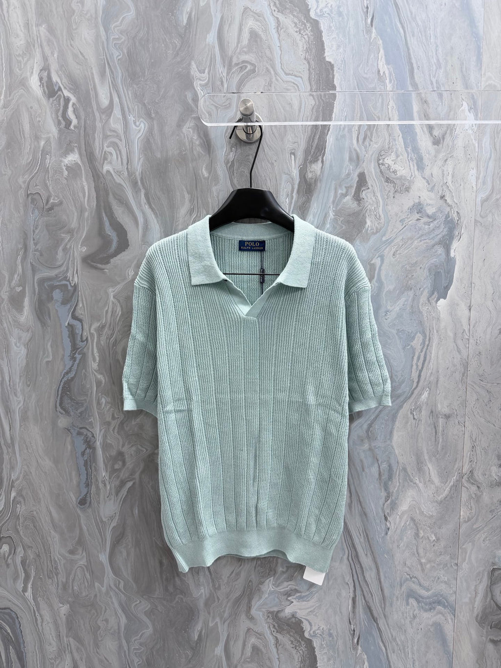 Light blue knit polo shirt with ribbed collar and short sleeves