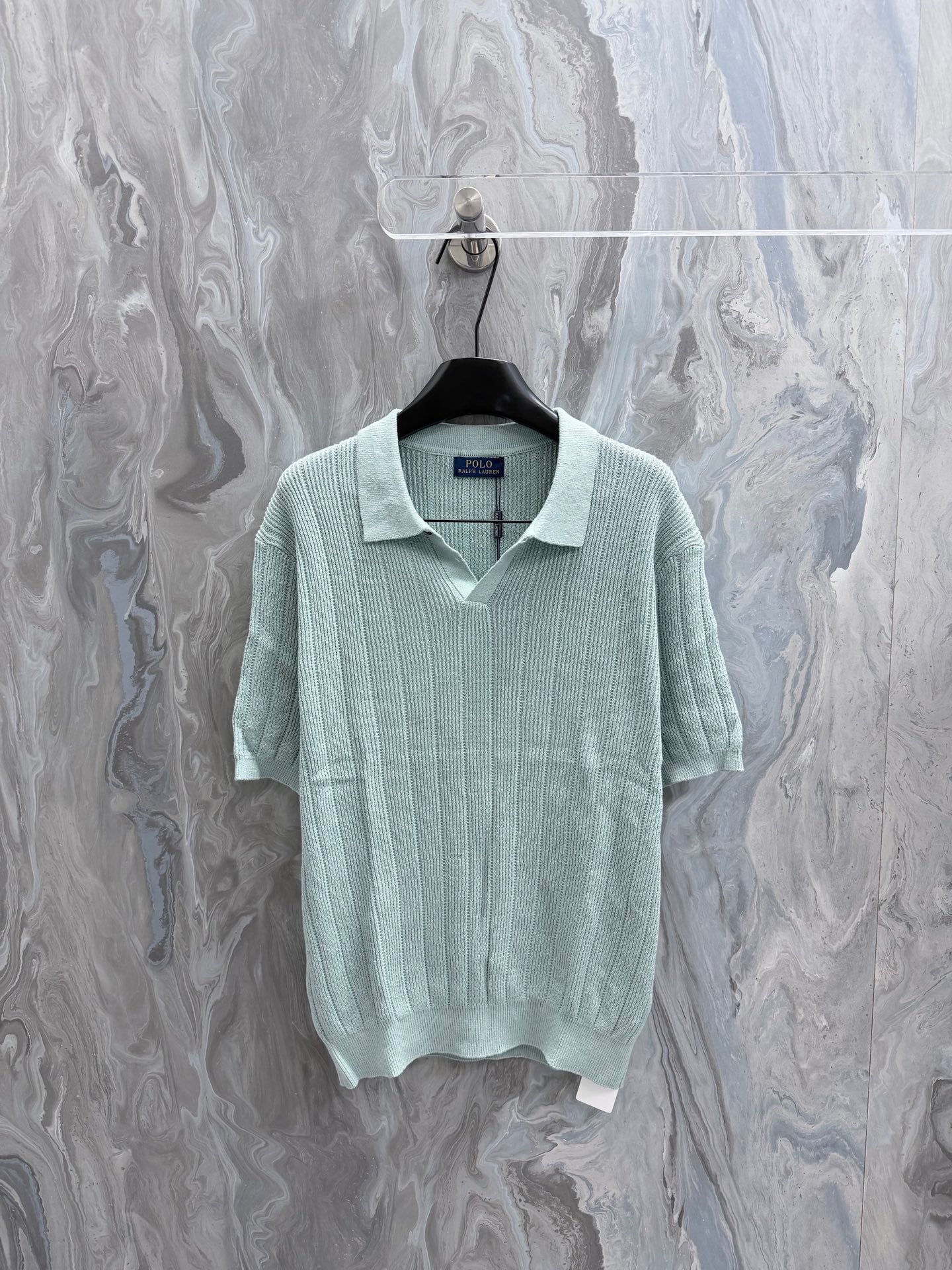 Light blue knit polo shirt with ribbed collar and short sleeves