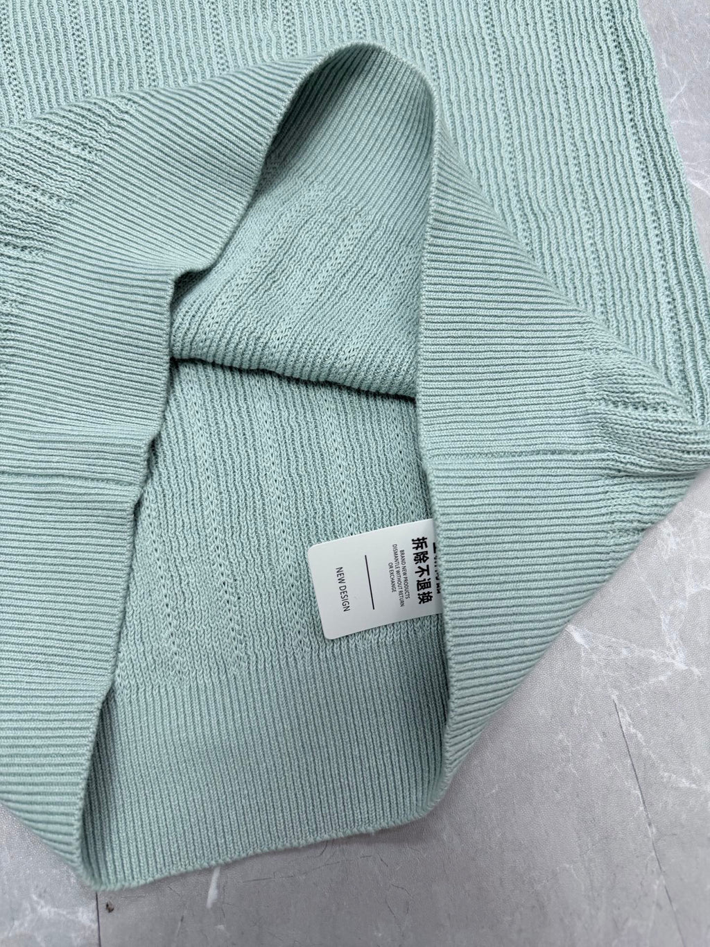 Light blue knit polo shirt folded with ribbed collar and short sleeves