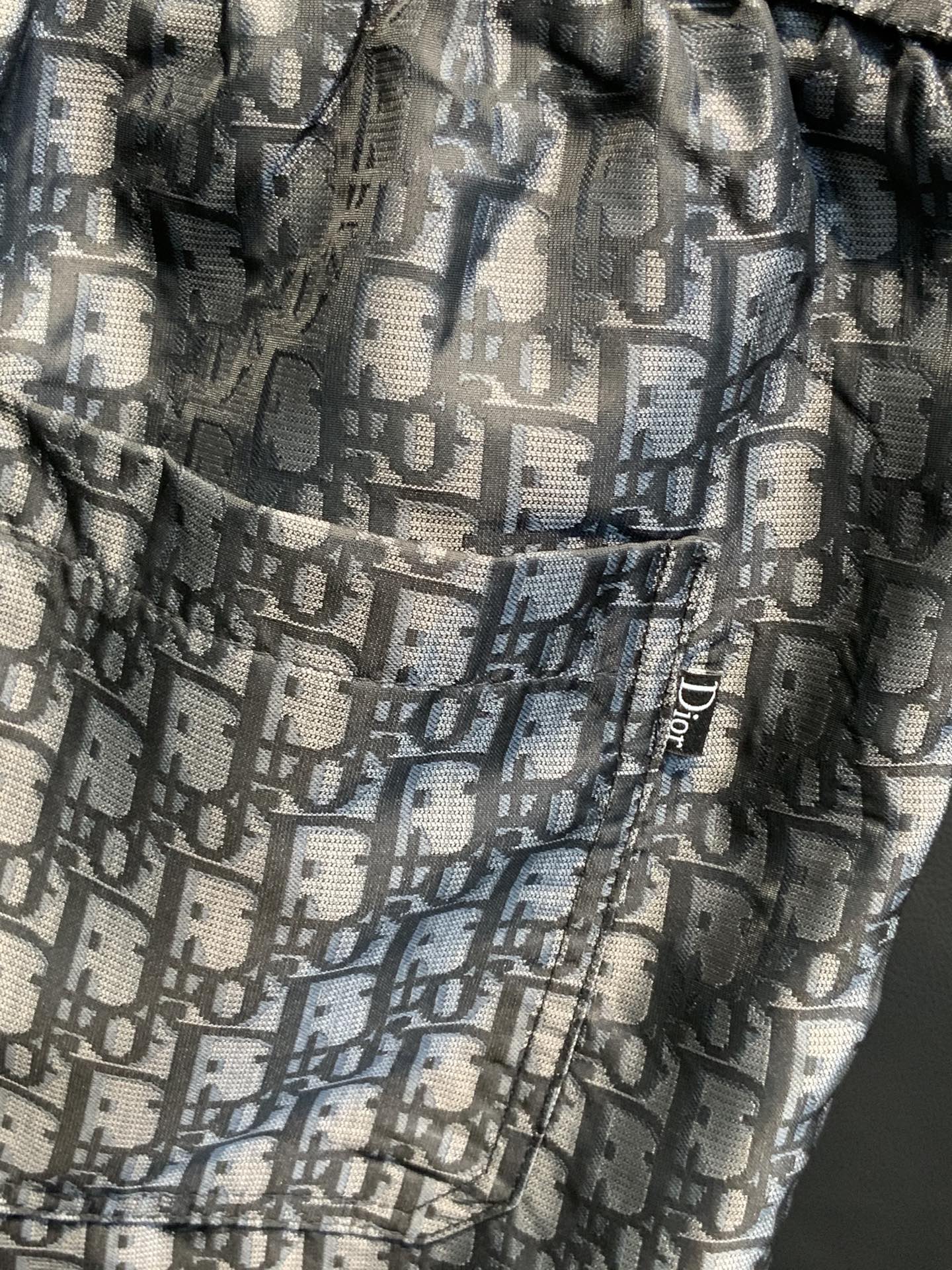 Dior monogram patterned pants fabric close-up with elastic waistband