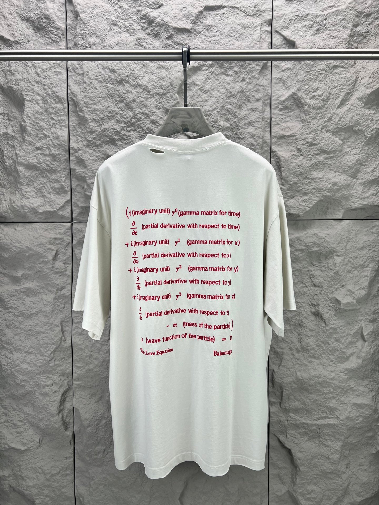 White short-sleeve T-shirt with small multiline red text graphic