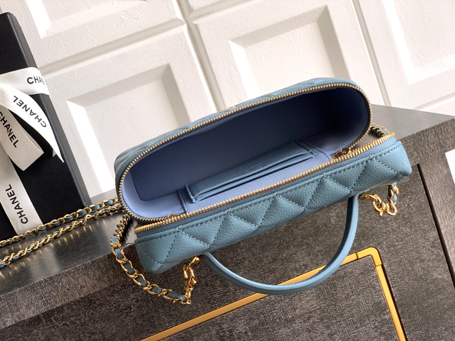 Chanel quilted bag open view in light blue with navy interior and chain strap
