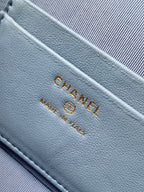 Chanel logo stamp on light blue fabric lining with gold-tone stitching