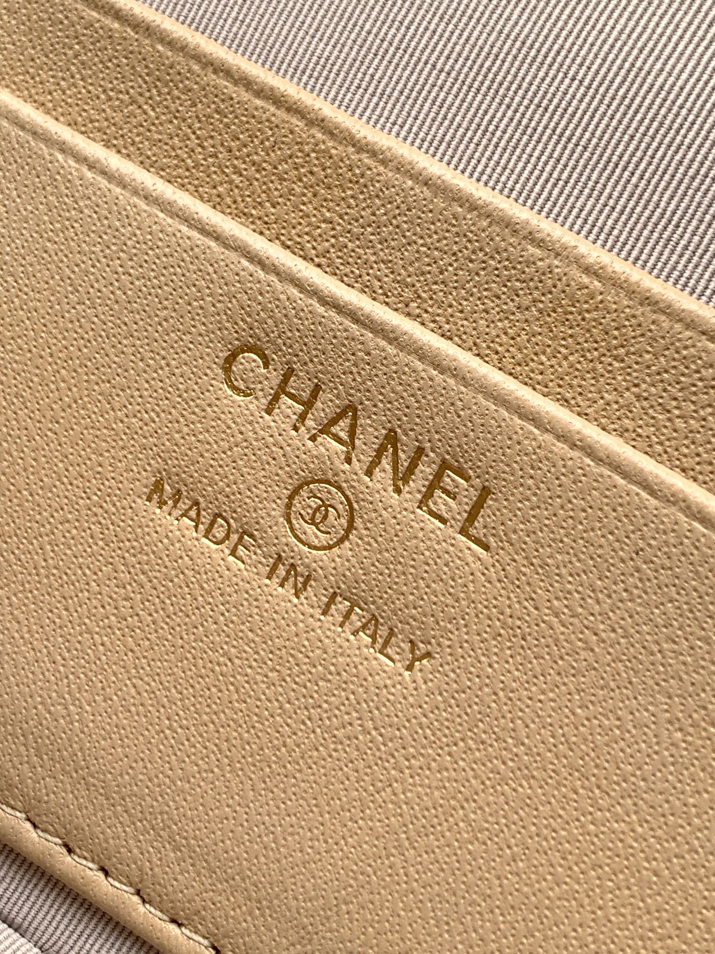Beige leather bag label with CHANEL text and Made in Italy