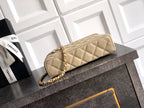 Quilted light beige clutch-style bag with gold chain strap and top handle
