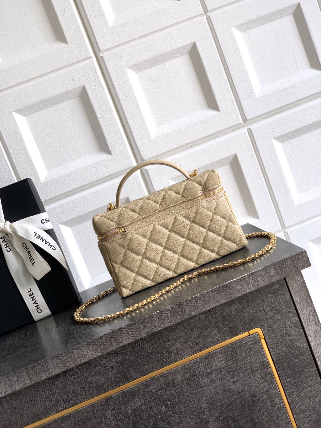 Quilted light beige handbag with structured shape and gold chain shoulder strap