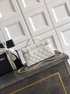 White quilted handbag with curved top handle and gold chain strap