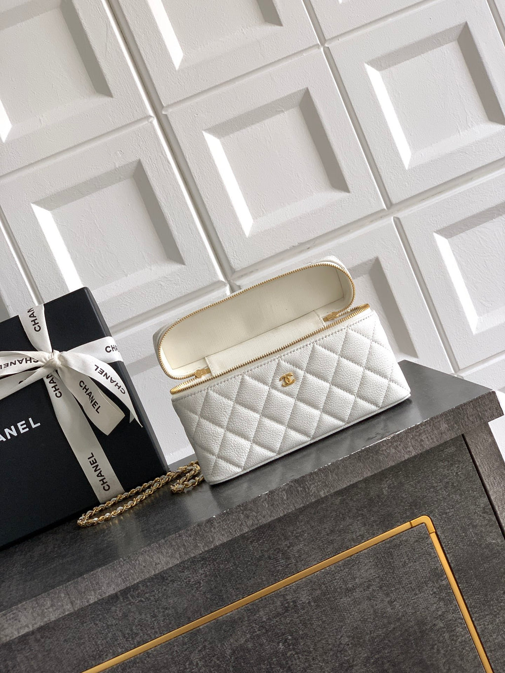 White quilted handbag with gold top handle and chain strap, small logo