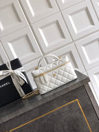 White quilted handbag with top handle and gold chain strap