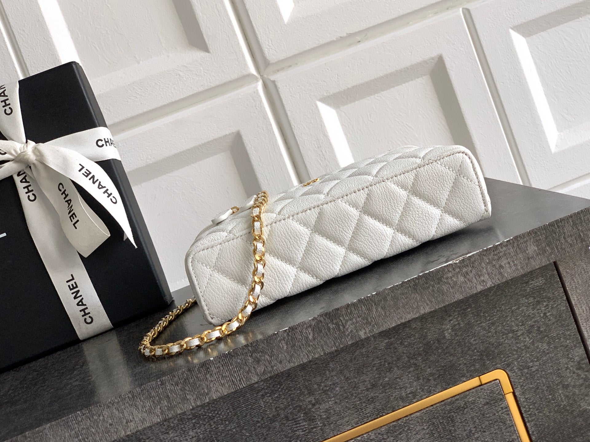 White quilted handbag with gold zipper and gold chain strap