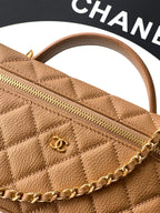 Tan quilted handbag close-up: gold zipper, chain strap, stitched diamond pattern.