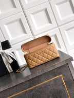 Tan quilted handbag with gold chain strap and open top flap showing interior lining.