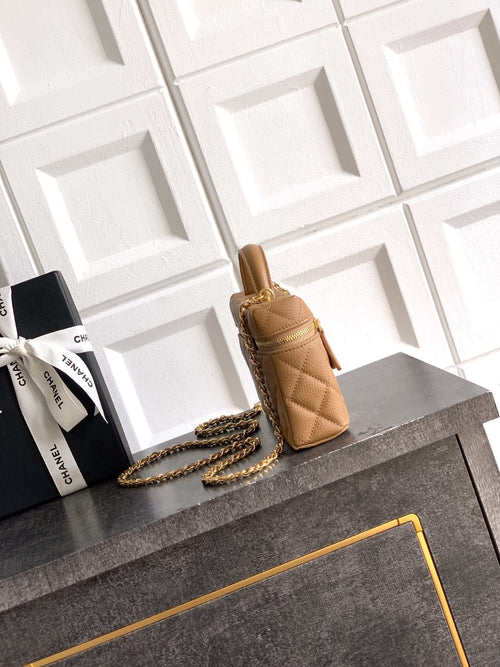 Tan quilted handbag with gold chain shoulder strap and zip top.