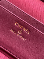 Chanel logo on burgundy leather strap with embossed text and stitching